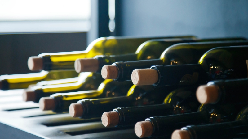 Red vinskih boca položеnih horizontalno na polici